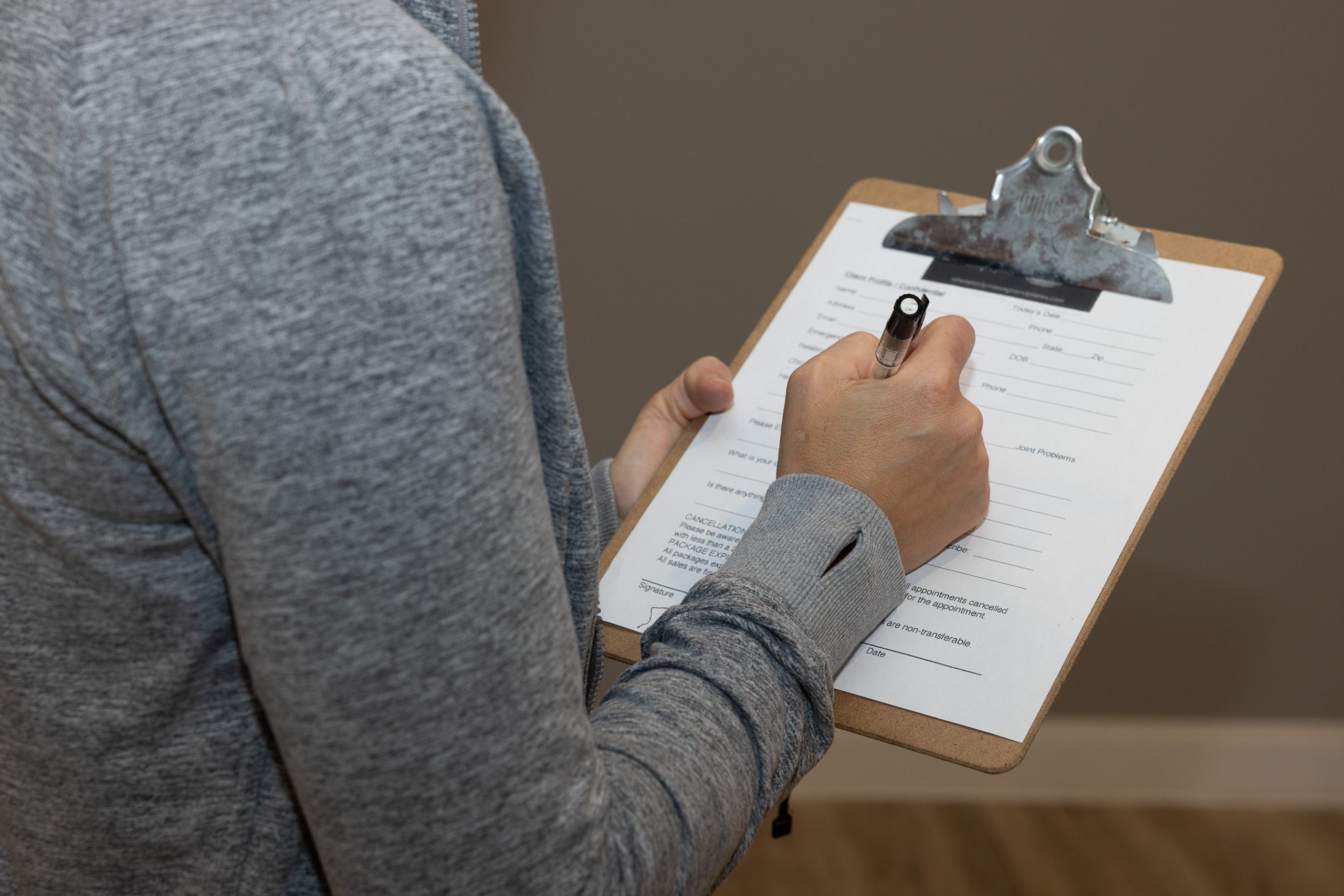 Woman completing intake form at Whole Body Massage and Pilates in Knoxville